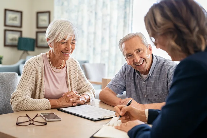 senior couple signing lease documents for assisted living facility