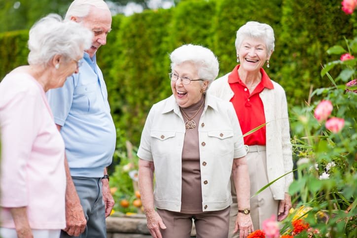 senior at an independent living facility walking outside by the garden