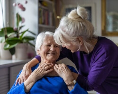 Woman hugging her elderly mother living in a memory care facility